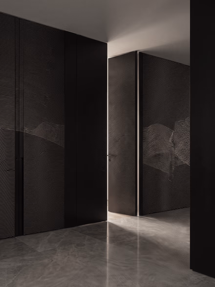 Grabado: una sala en penumbra con una puerta entreabierta por la que entra la luz.