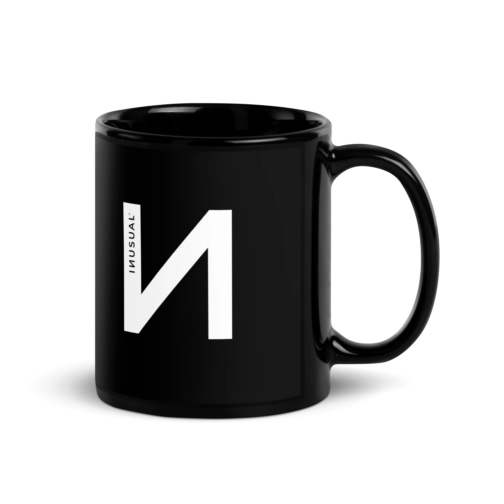Taza negra brillante de INUSUAL con el logotipo en blanco.